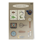 Vinyl sticker sheet, 'Botanist's Desk' with illustrations of a book, coffee cup, magnifying glass, plant scrapbook, butterfly specimen, and other items on a wooden surface.