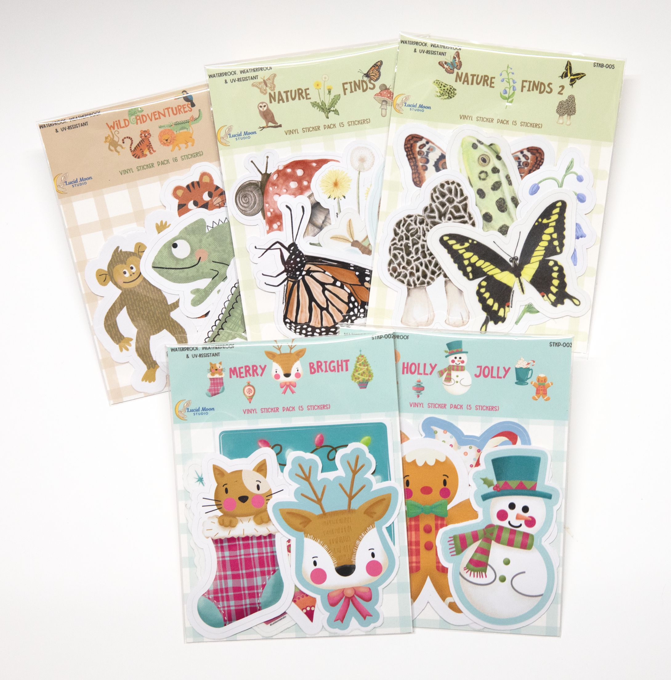 Five different sticker packs each featuring a selection of 5-6 themed vinyl stickers in animal, nature, and Christmas designs.
