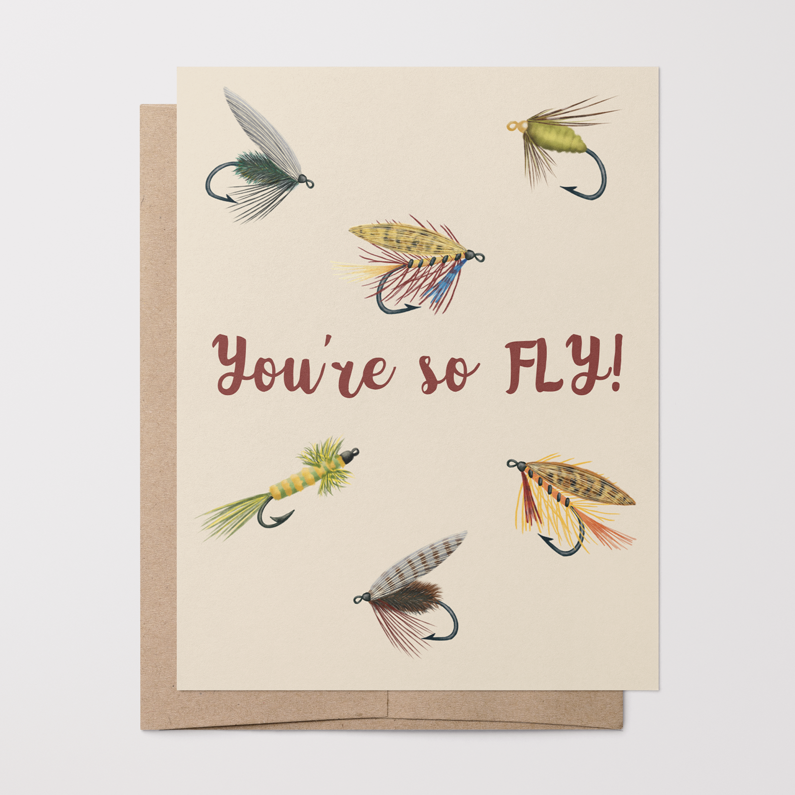 Love/friendship card with 6 fishing fly illustrations and text "You're so FLY!" on a tan background on top of a brown kraft envelope.