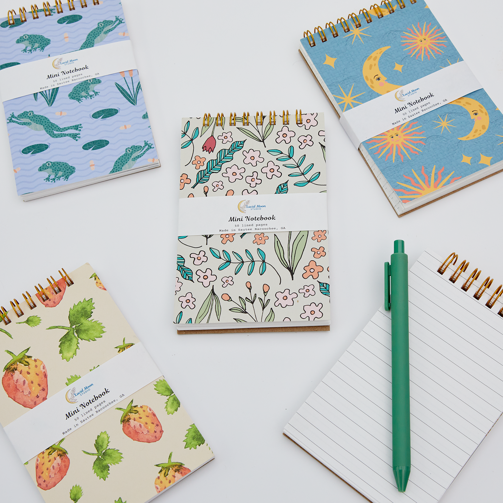 An assortment of colorful jotter spiral notebooks with nature-inspired patterns on the covers and lined pages