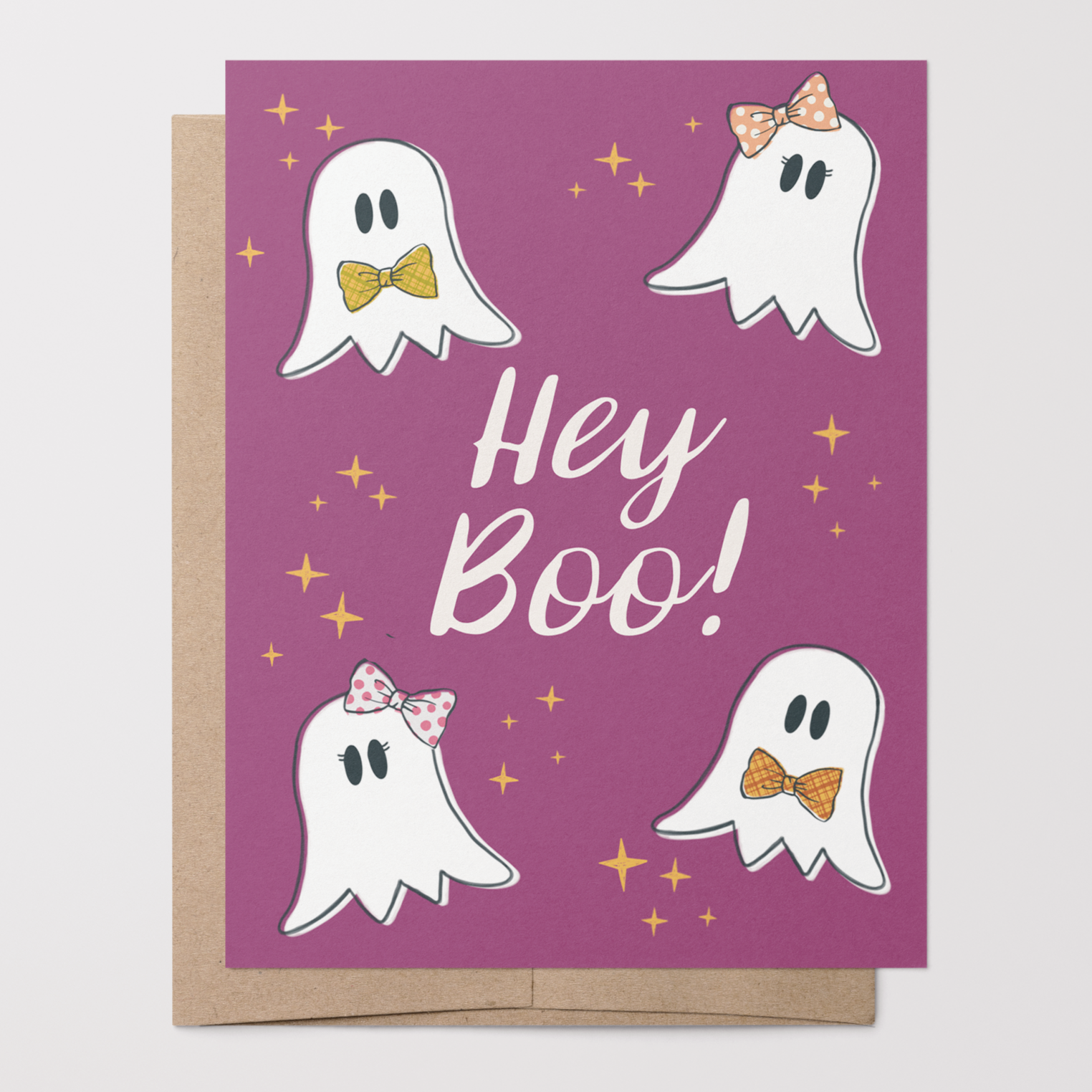 Halloween-themed greeting card with hand-drawn ghosts and 'Hey Boo!' text on a purple background with a brown kraft envelope.