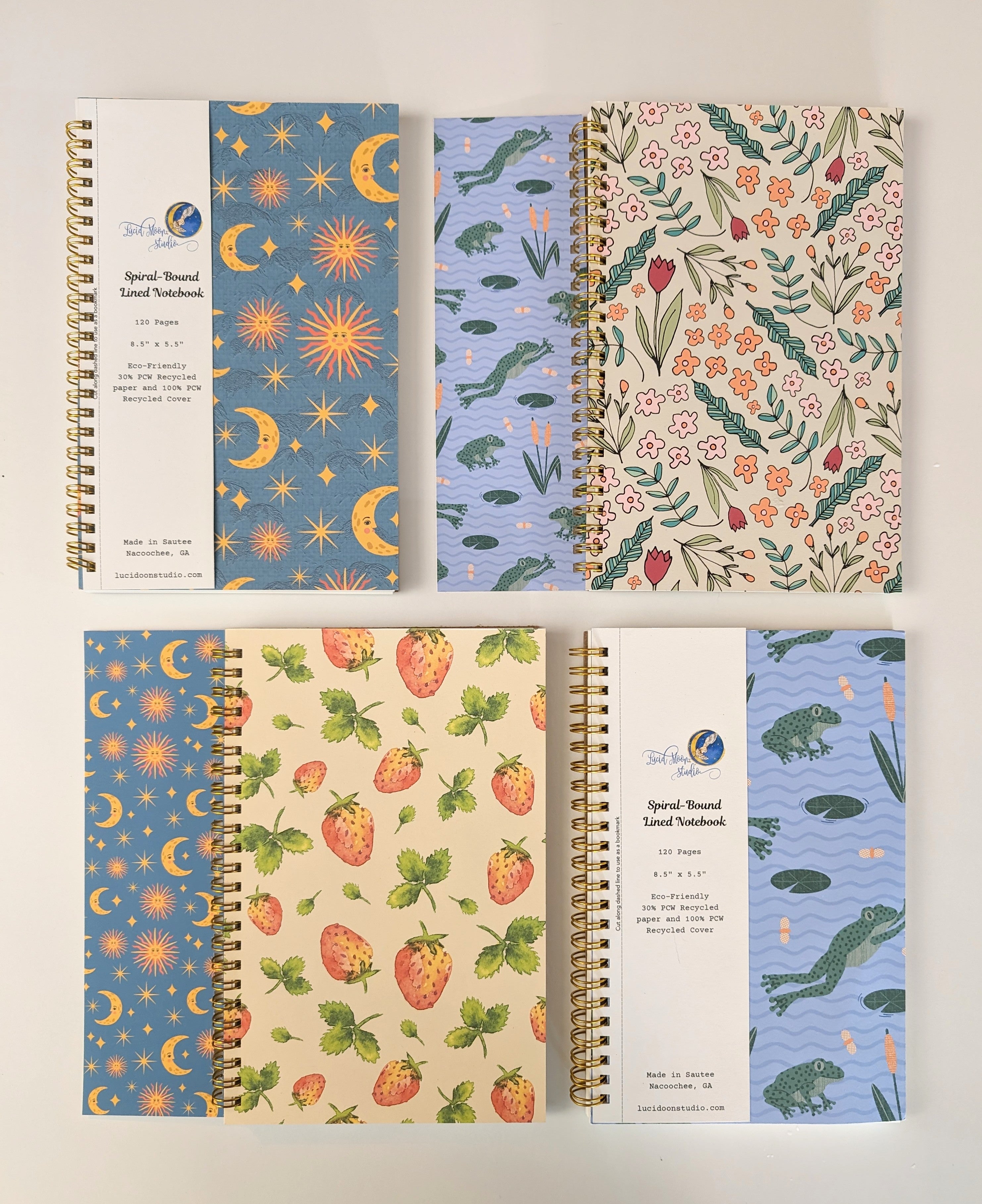 Assortment of spiral notebooks with various colorful patterns and detachable bookmark labels on a white background