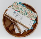 Stack of notebooks with floral design on a wooden plate