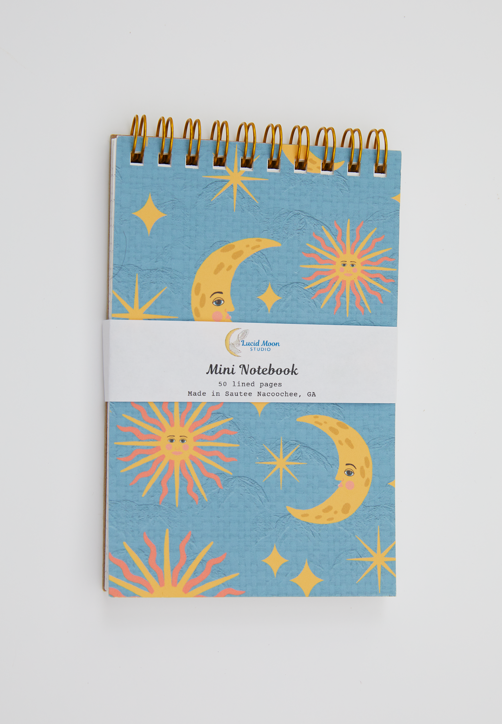 Mini spiral notebook with celestial design on a blue background on the cover.