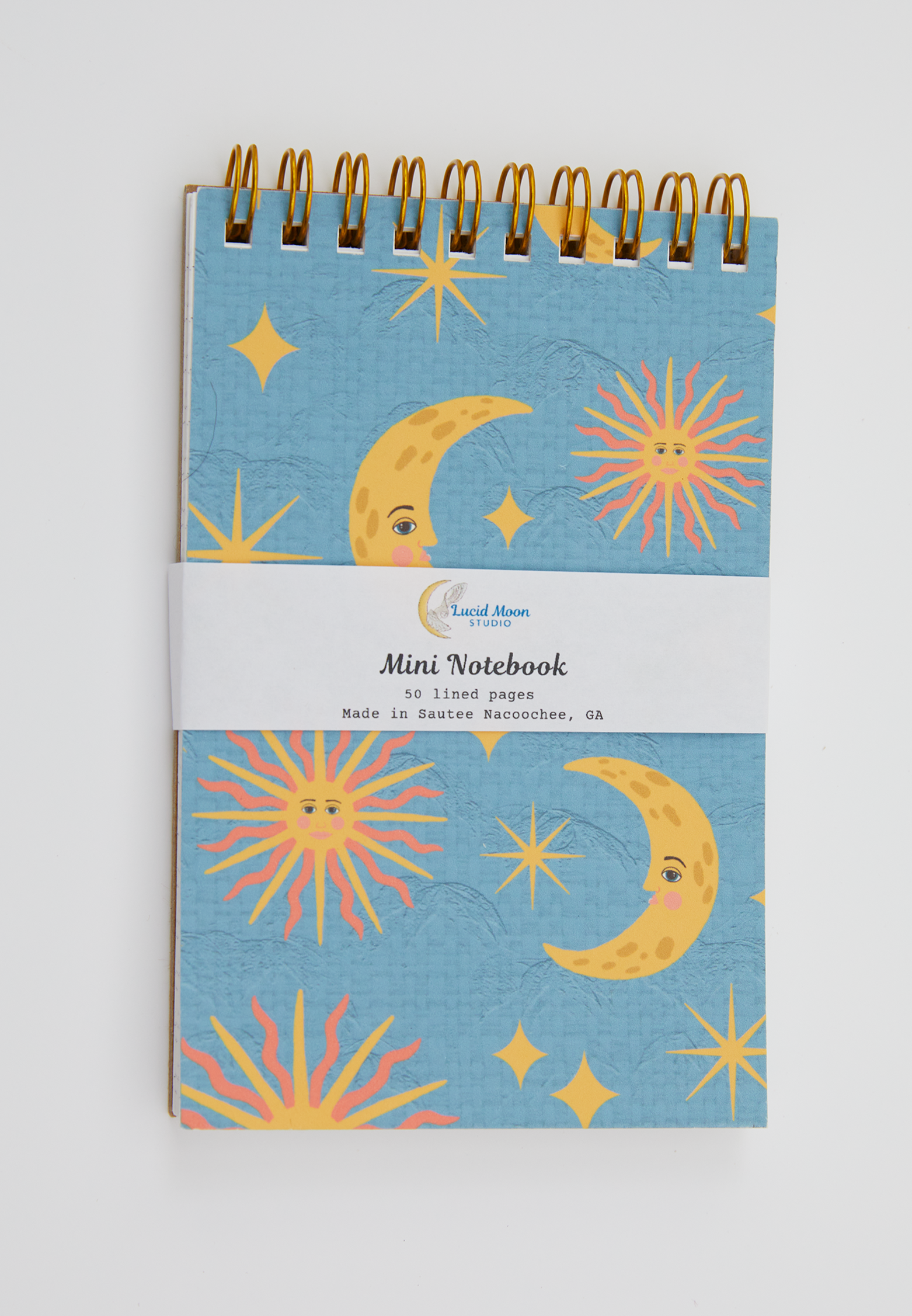Mini spiral notebook with celestial design on a blue background on the cover.