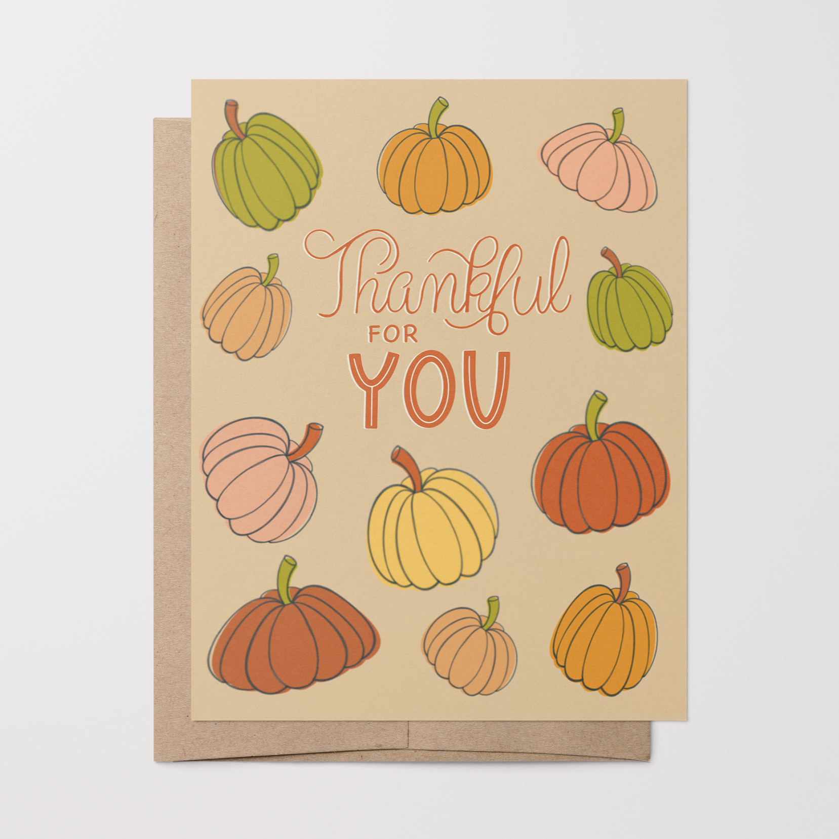 Greeting card with pastel hand-drawn pumpkins and 'Thankful for You' text on a beige background with a brown kraft envelope.