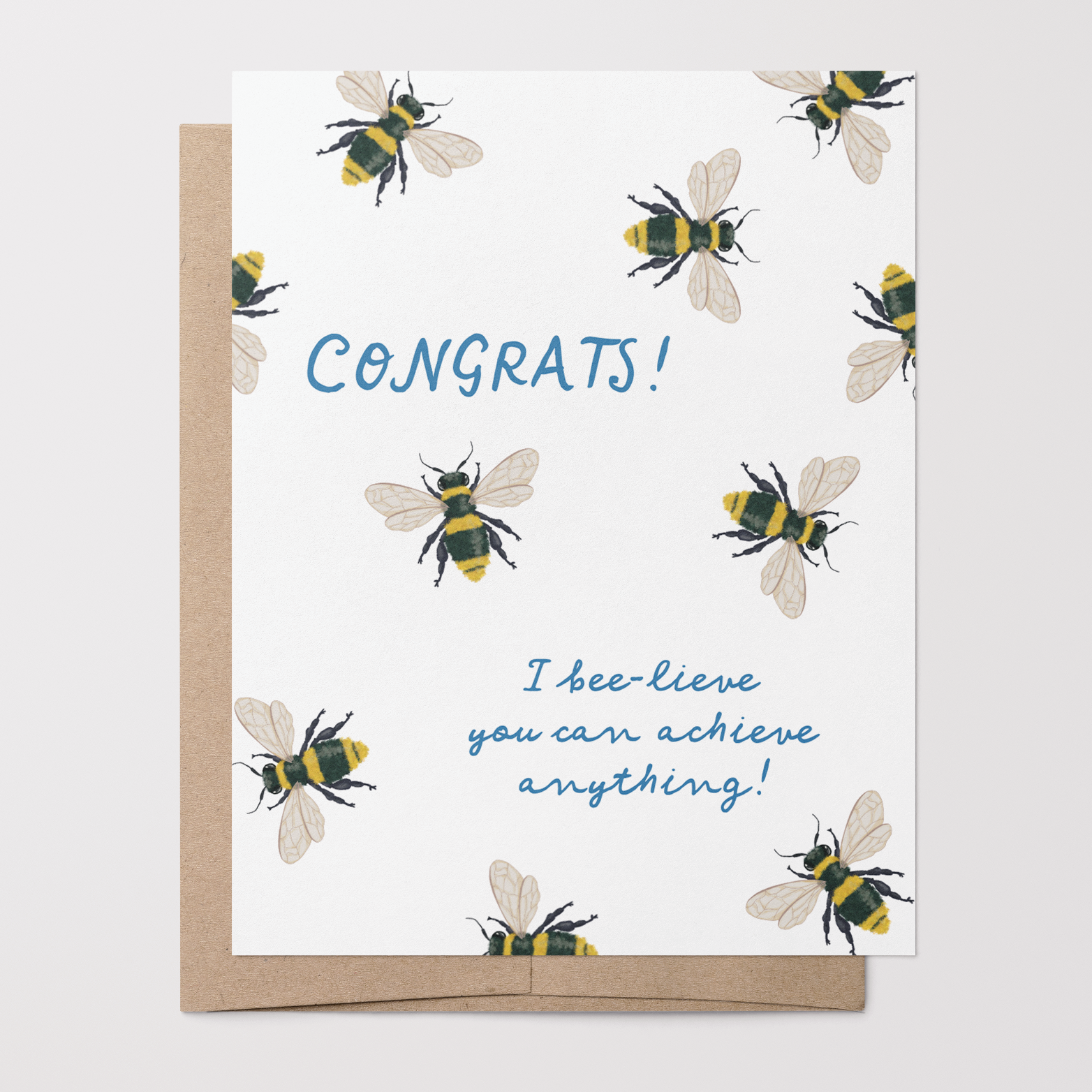 Greeting card with hand-drawn bee illustrations on a white background with blue text that says "Congrats! I bee-lieve you can achieve anything!" with a brown kraft envelope.