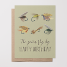 Birthday card with 6 fishing fly illustrations and text "The years fly by HAPPY BIRTHDAY" on a light green background on top of a brown kraft envelope.
