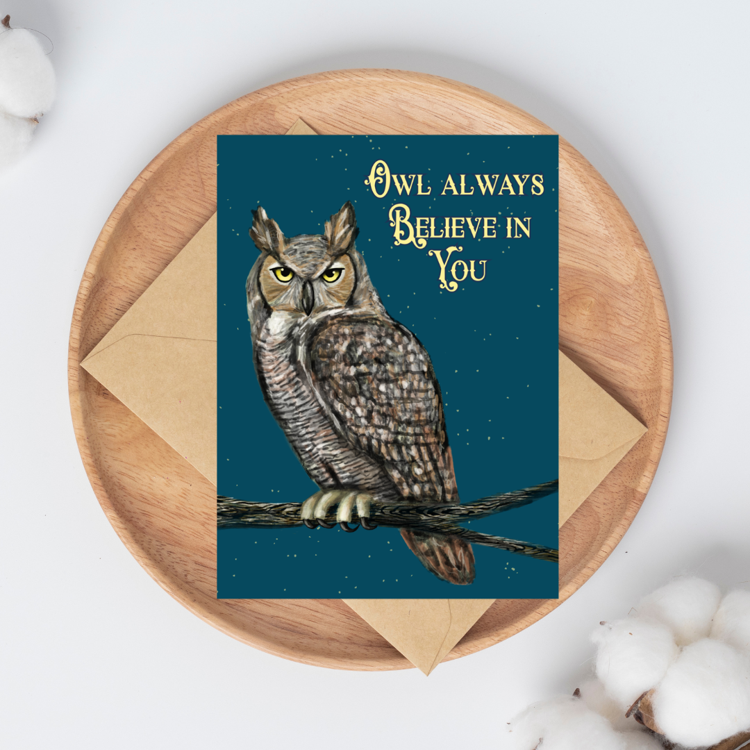 Greeting card with a painted Great Horned owl on a branch illustration on a dark blue background with stars on top of a brown kraft envelope.