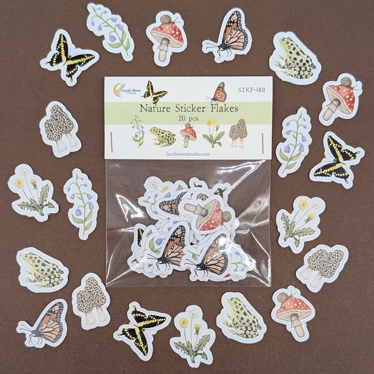 A set of nature-themed sticker decals arranged around a clear plastic bag containing the remaining stickers, with a label card reading 'Nature Sticker Decals' on a brown background.